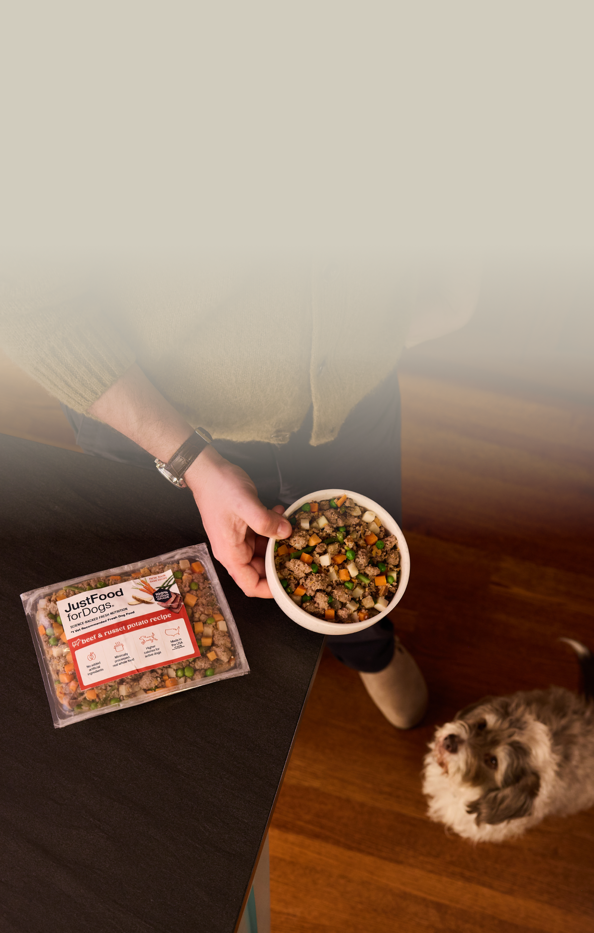 picture of a man holding a dog and bowl of food